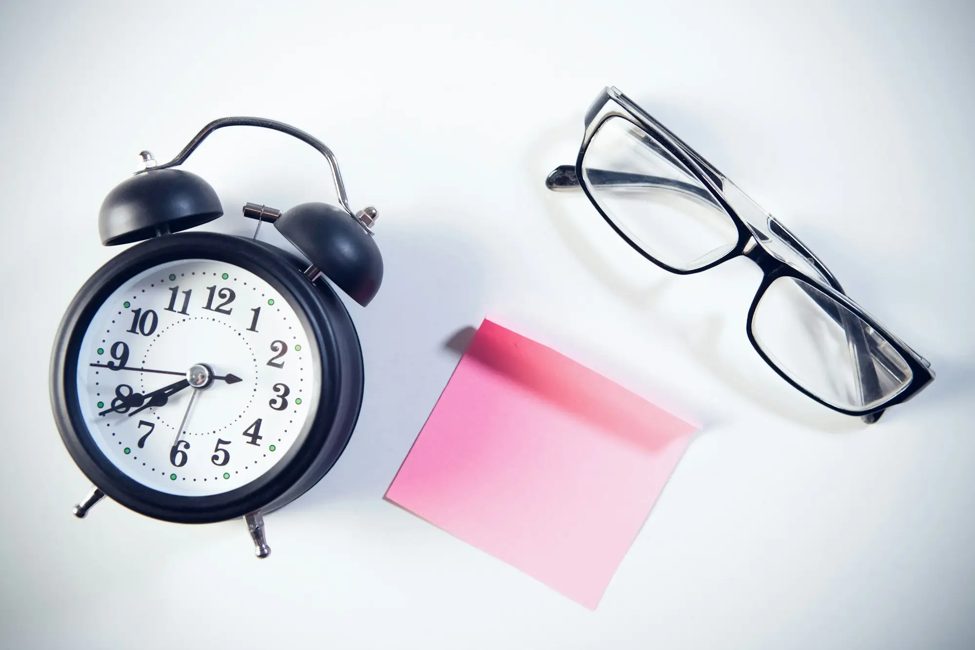 Wall clock above a desk with a checklist and documents being sorted