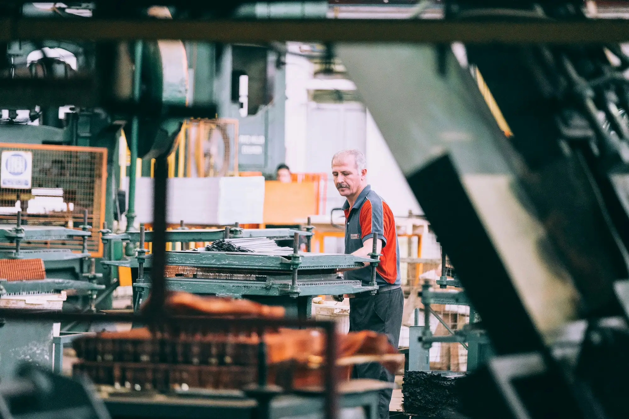 Technician repairing a stopped industrial machine on a factory floor