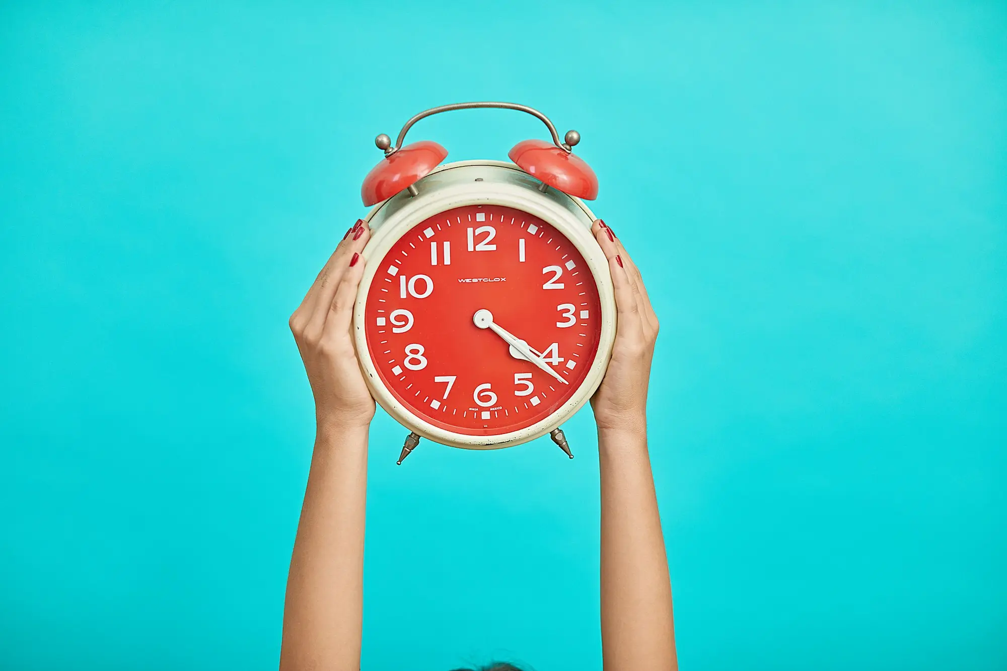 Hands holding up a red alarm clock, a reminder that the 21-day window to set aside a statutory demand cannot be extended
